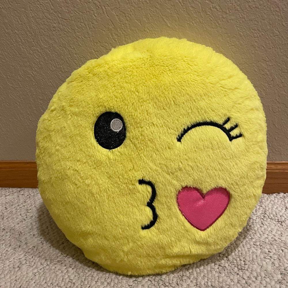 Justice winking and blowing kiss emoji pillow.